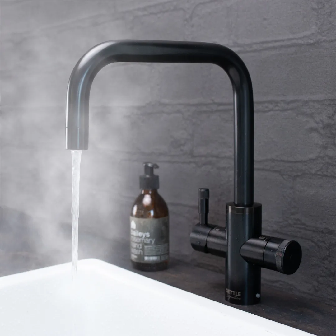 A black boiling water tap pouring water