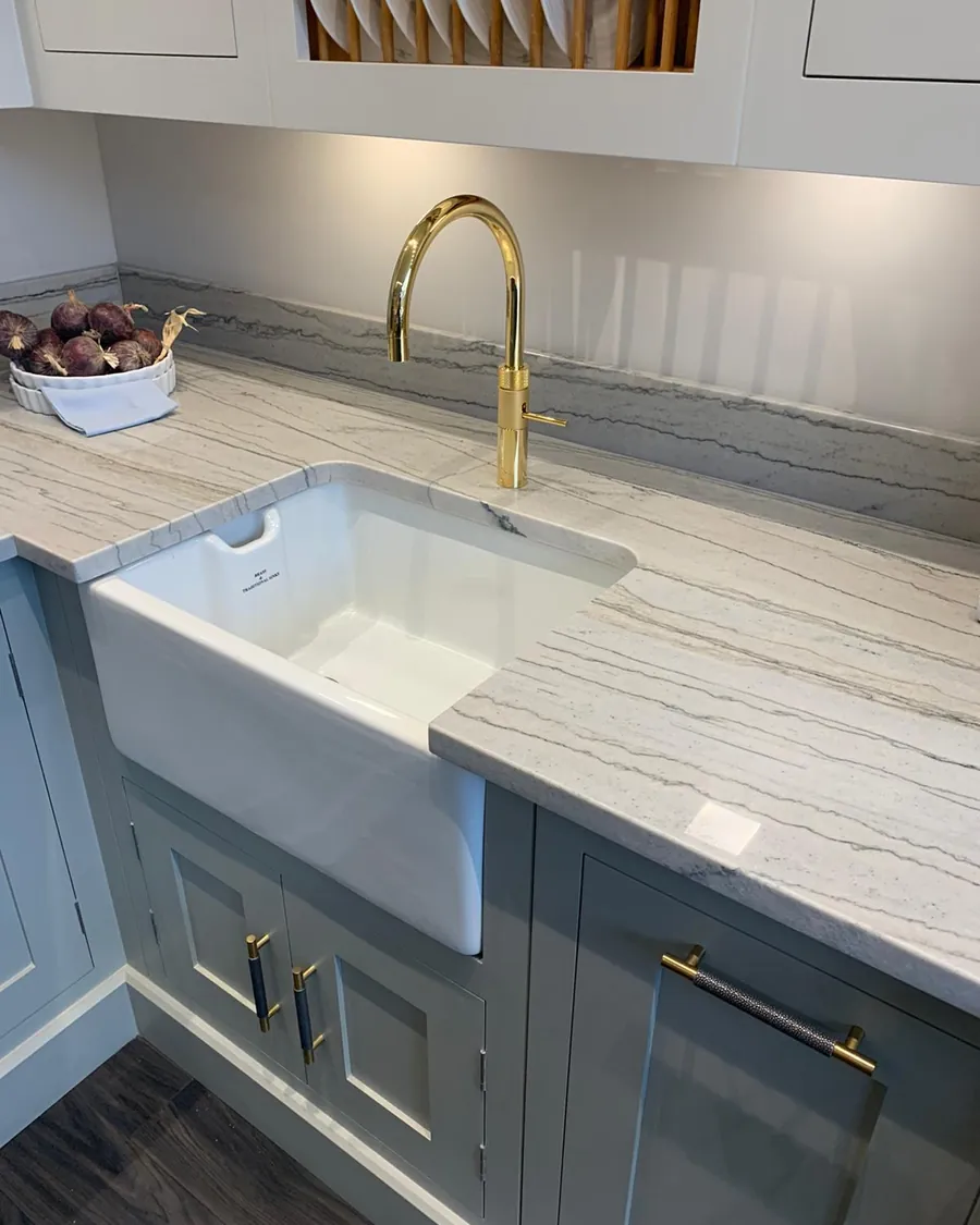 Gold boiling water tap fitted over a white ceramic sink in a grey shaker kitchen