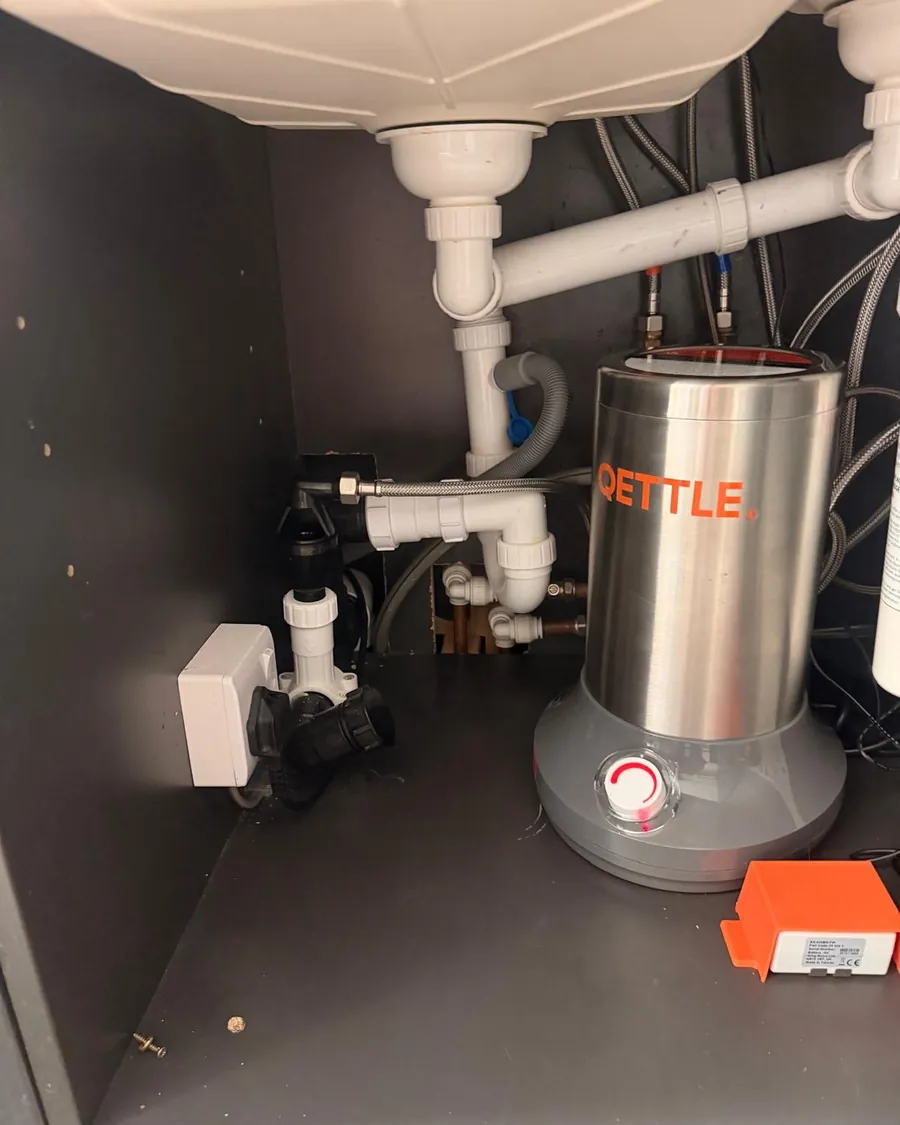 QETTLE boiler tank and pipework fitted neatly in the cupboard under a sink